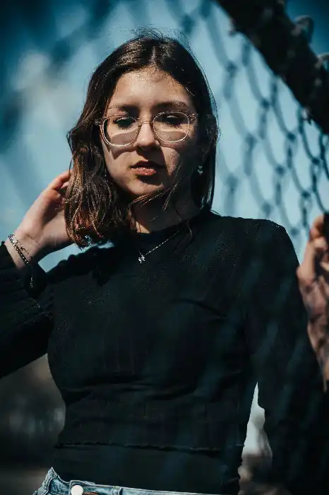 Portrait d'un jeune femme à lunettes, pensive avec un pull noir