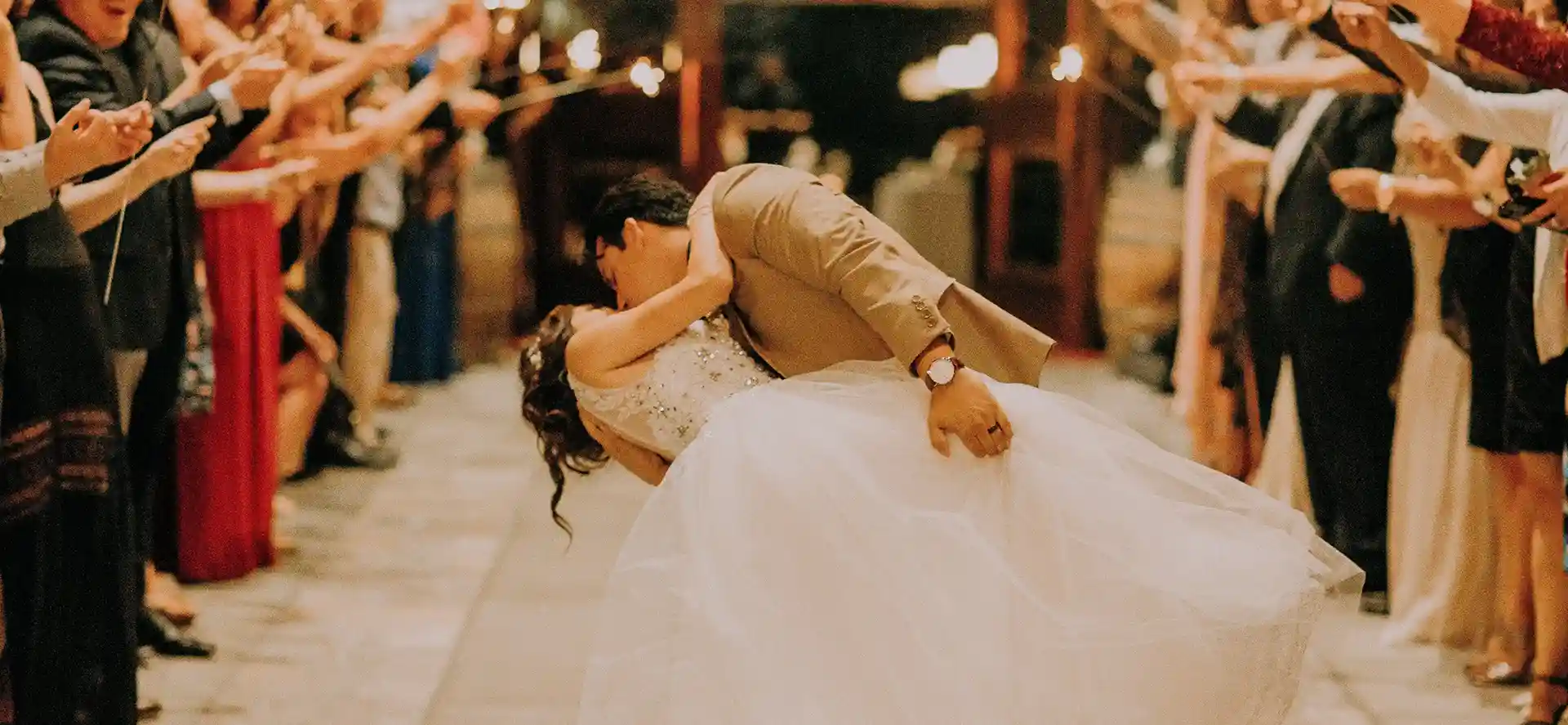 Un couple de marié s'embrassant devant leurs convives